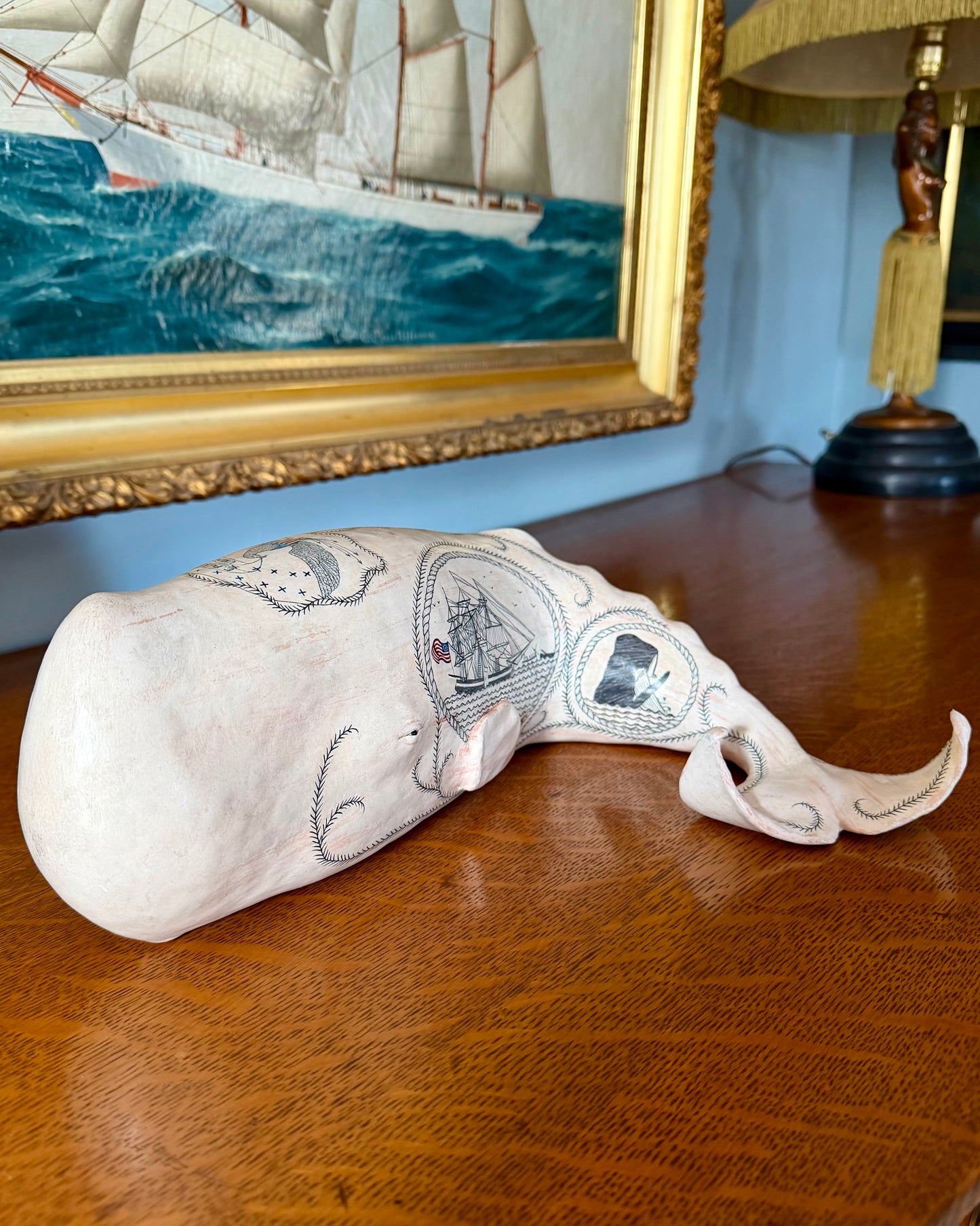 Hand-crafted porcelain sperm whale sculpture with scrimshaw designs painted all over the surface