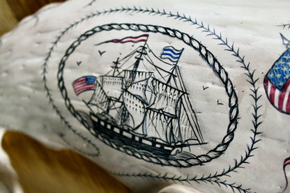 Hanging sperm whale sculpture by Laura Rotelli.  Sperm whale porcelain sculpture with scrimshaw designs of whaling scenes and ships painted on the surface.  Maritime art, marine art, folk art, Americana, patriotic art