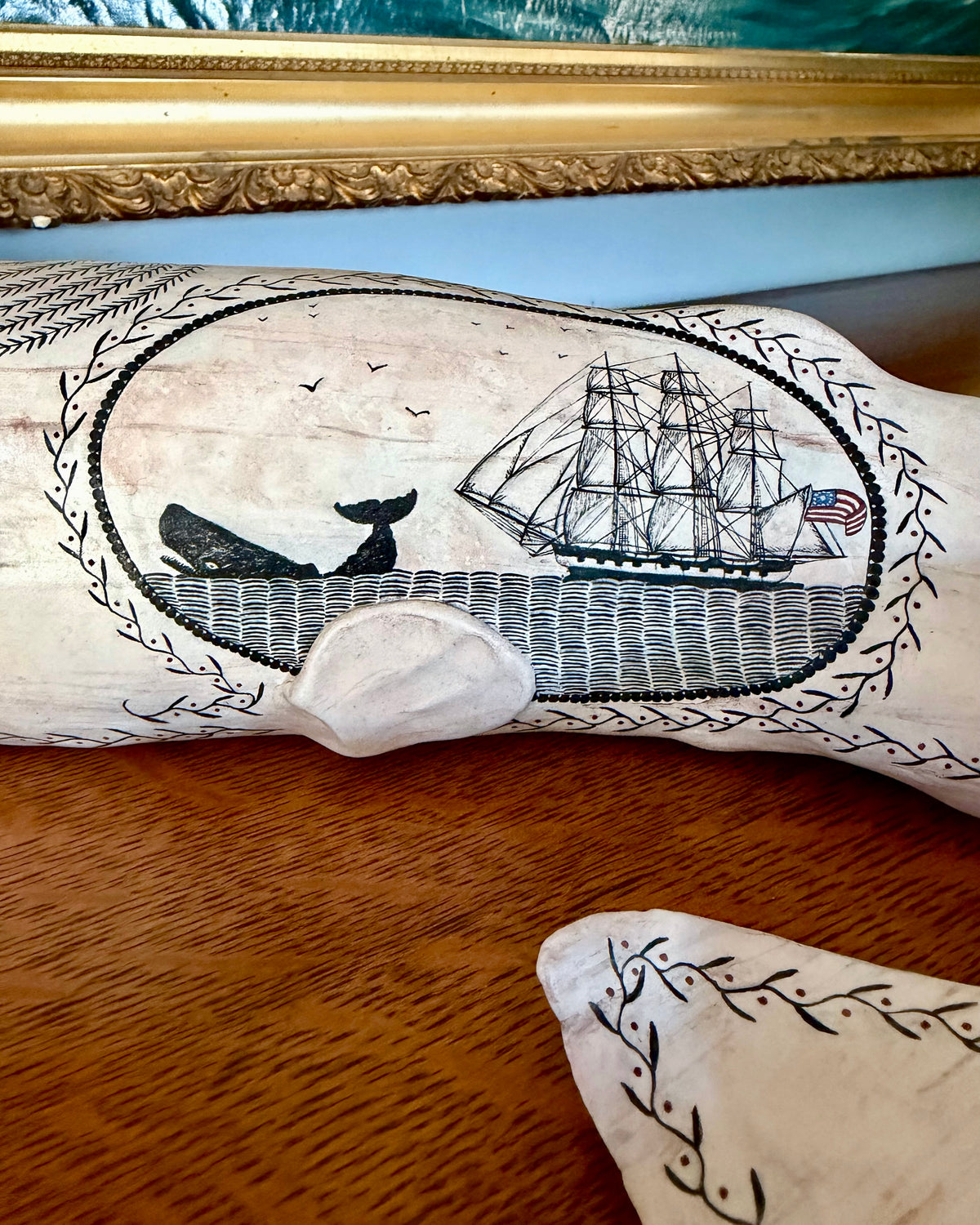 American contemporary folk art by Laura Rotelli.   Porcelain sperm whale sculpture with painted scrimshaw designs of sailing ships and whaling scenes, coastal maritime nautical artwork.