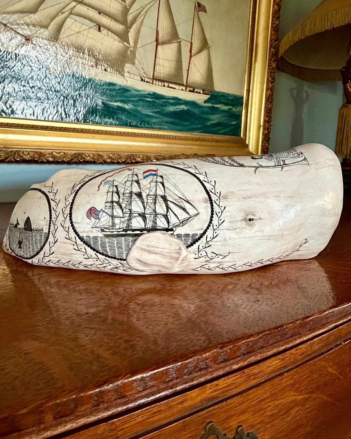 American contemporary folk art by Laura Rotelli.   Porcelain sperm whale sculpture with painted scrimshaw designs of sailing ships and whaling scenes, coastal maritime nautical artwork.