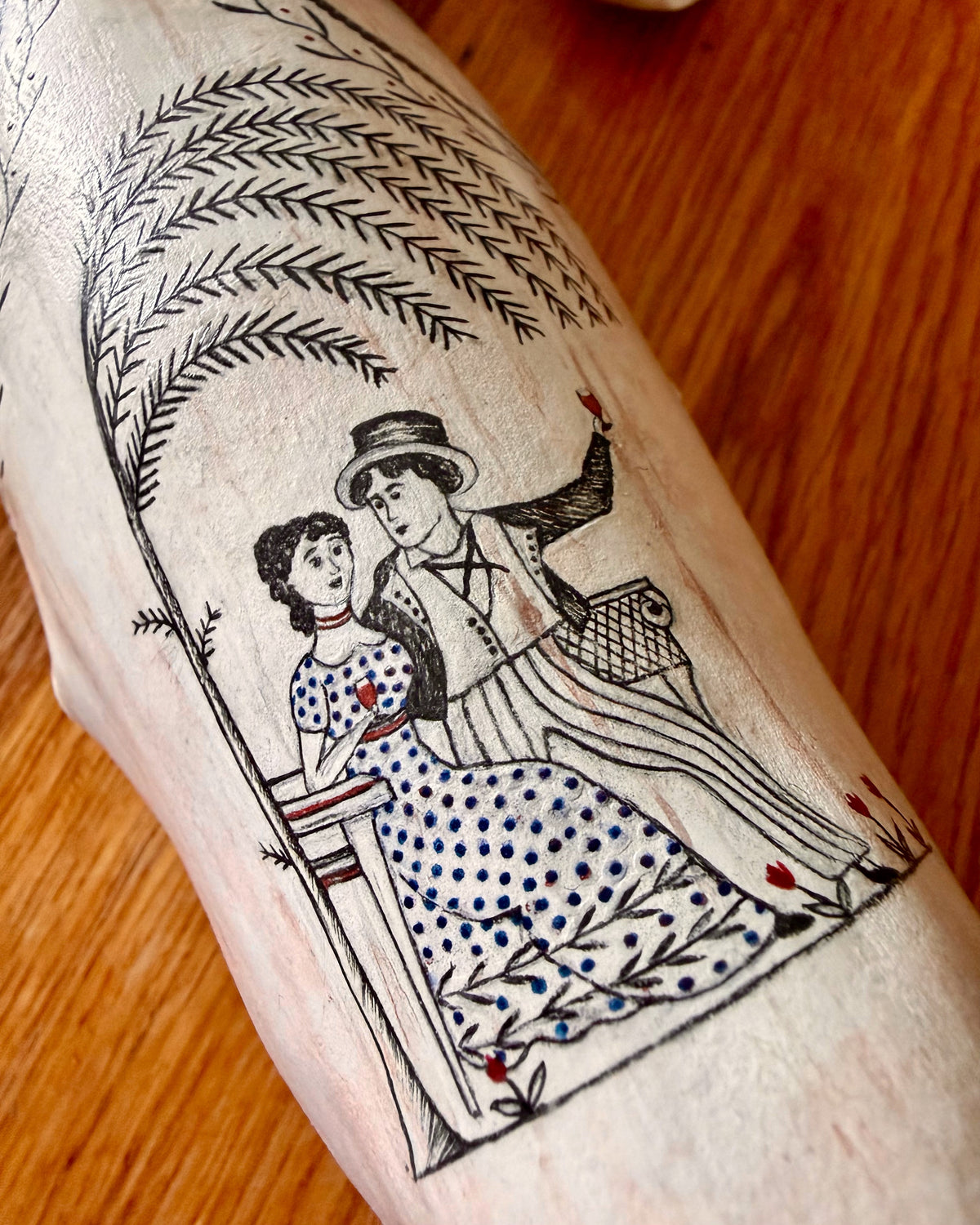 Close-up of a seated couple painted within a leafy border on Edward II's back.