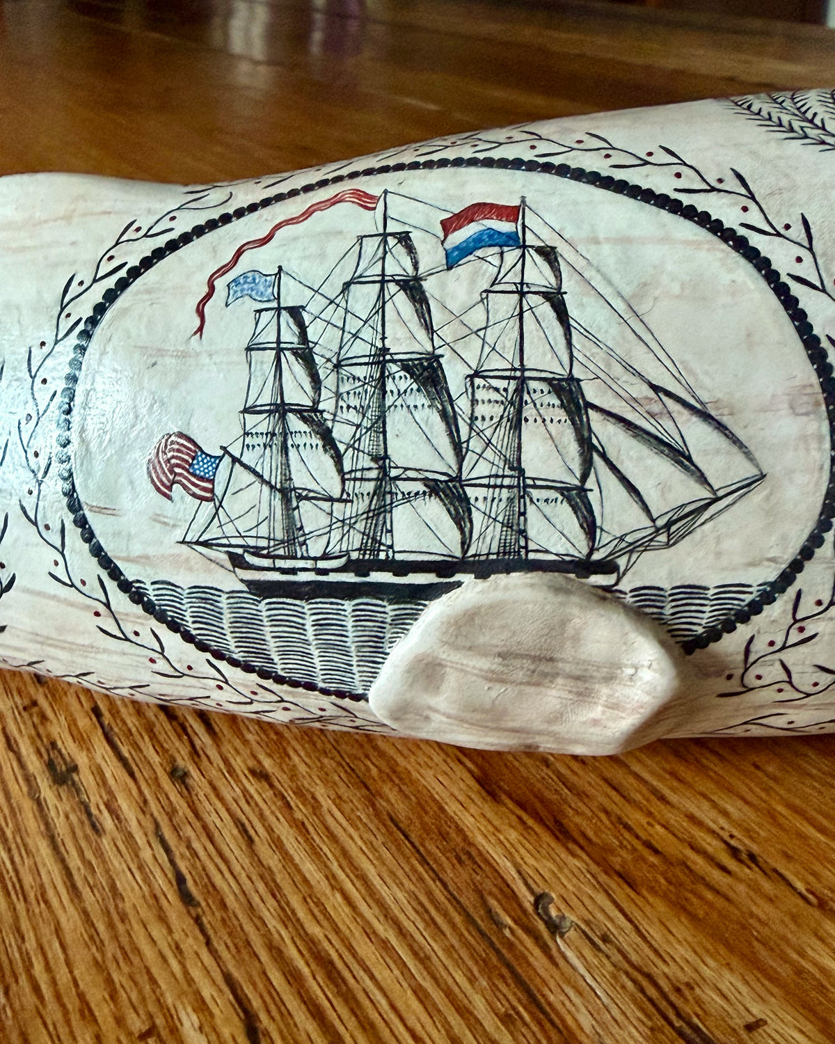 American contemporary folk art by Laura Rotelli.   Porcelain sperm whale sculpture with painted scrimshaw designs of sailing ships and whaling scenes, coastal maritime nautical artwork.