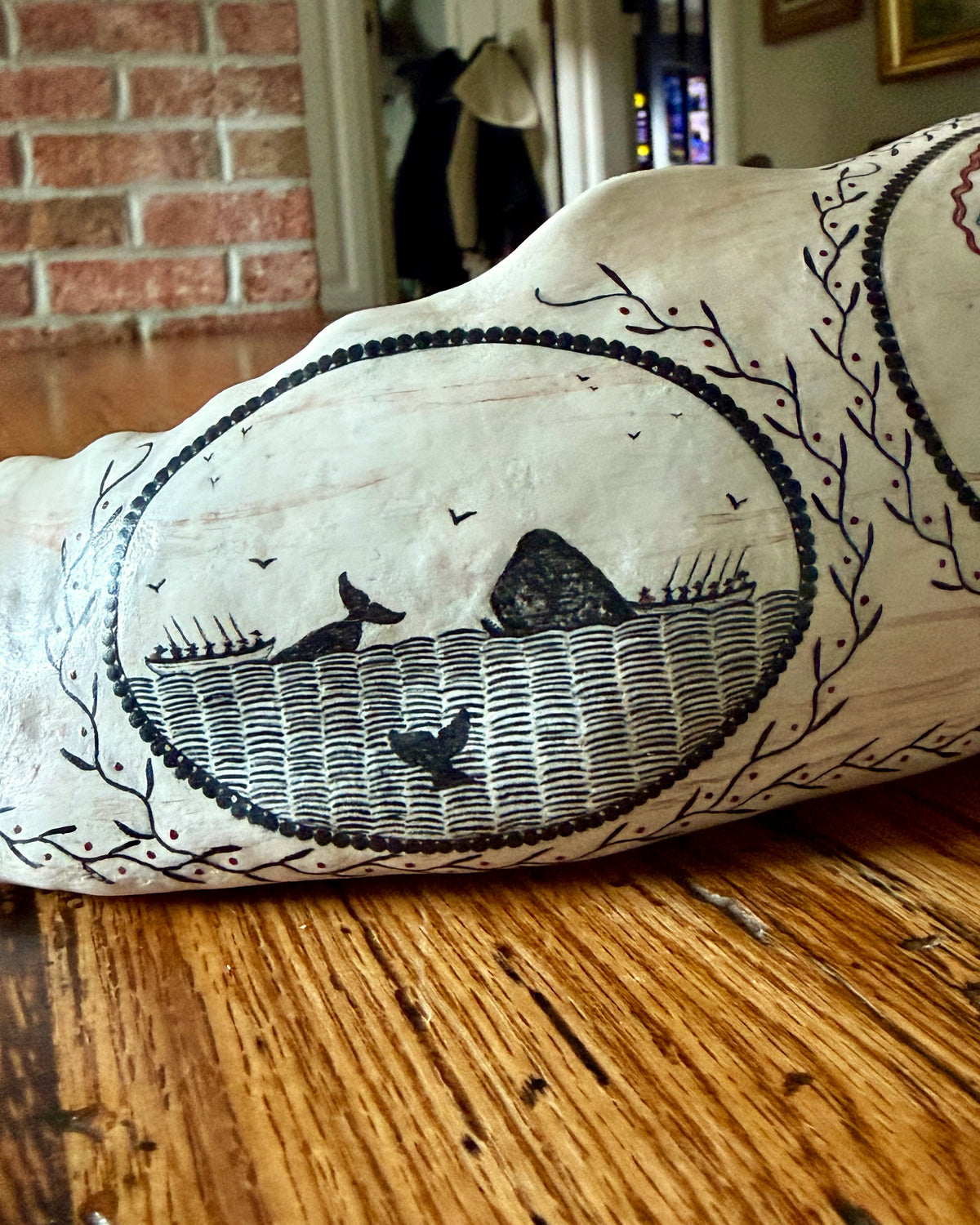 American contemporary folk art by Laura Rotelli.   Porcelain sperm whale sculpture with painted scrimshaw designs of sailing ships and whaling scenes, coastal maritime nautical artwork.
