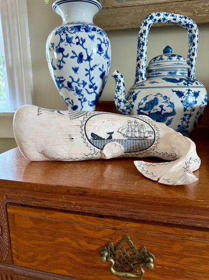 American contemporary folk art by Laura Rotelli.   Porcelain sperm whale sculpture with painted scrimshaw designs of sailing ships and whaling scenes, coastal maritime nautical artwork.