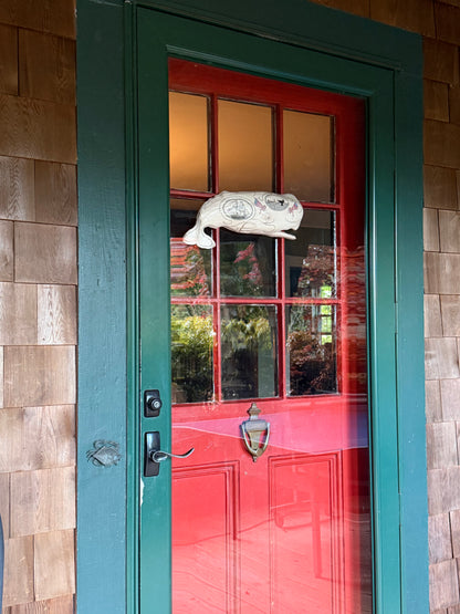 Hanging sperm whale sculpture by Laura Rotelli.  Sperm whale porcelain sculpture with scrimshaw designs of whaling scenes and ships painted on the surface.  Maritime art, marine art, folk art, Americana, patriotic art