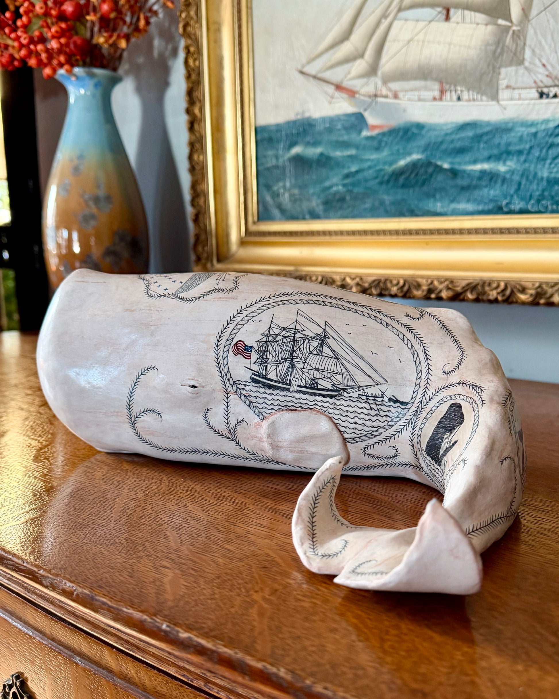 Sperm whale sculpture with scrimshaw design by Laura Rotelli.  Iconic Americana Maritime artwork for nautical and coastal decor